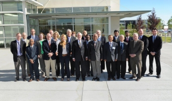 Photo of a group of people standing together outside, facing the camera.