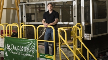 Matt Sallas stands outside of the BAAM machine at Oak Ridge National Laboratory Matt Sallas stands outside of the BAAM machine at Oak Ridge National Laboratory.