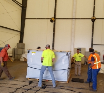 Workers conduct macro encapsulation to treat waste inside the soft-sided building.
