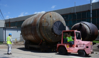 Workers move a 33-ton converter. More than 1,700 similar pieces of the process gas equipment will be cut into segments and allow their steel shells to be safely placed in the Onsite Waste Disposal Facility.