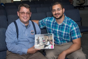 Bill Wabbersen, left, holds a photograph from 2003 when he taught students about engineers at Davidson Fine Arts. Thomas Nail, right, is pictured in the photo immediately below (second from left) as a seventh-grader in Wabbersen's class.