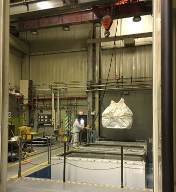 Crews at the 324 Building use a crane to lift a large piece of packaged waste, retrieved from the buildingâs airlock, into a waste box for shipment to the Hanford Siteâs regulated landfill.