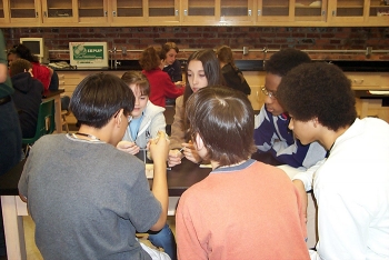 Thomas Nail, far right, works with classmates trying to balance eight nails on top of one nail during an education outreach event.