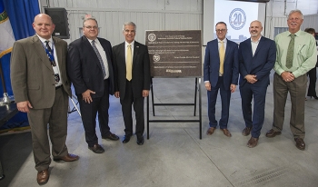 Paul Vandervert, Eric Dean, Glenn Podonsky, Dan Stepano, Bob Wilkinson and Gordon McCleary stand near a plaque unveiled for the celebration.