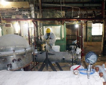 A worker removes asbestos from Building 7500.