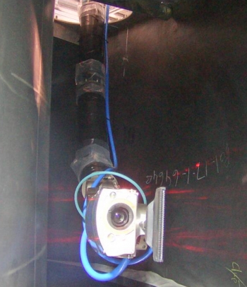 The robotic snake arm enters the mockup of a calcined waste storage bin.