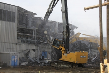 his excavator outfitted with high-reach shears allows operator Cody Krisher to access the highest points of the Plutonium Finish Plant main processing facility to demolish the building piece by piece.