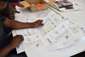 Photo of a man reading a specification sheet.