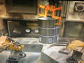 A drum containing high fissile gram equivalent waste is lowered through Port 16, located in the floor of the Advanced Mixed Waste Treatment Facilityâs South Boxline.