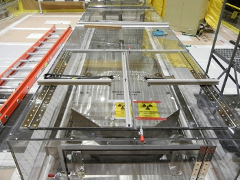 Workers fabricated a port cover actuator mechanism to allow operators to open and close the hot cellâs hatch cover with a cordless drill.