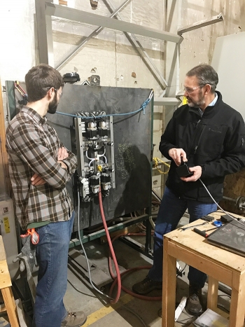 Calcine Retrieval Project Manager Howard Forsythe (right) tests the robotic crawler on a vertical surface.