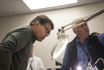 Energy Secretary Rick Perry examines an item in the FBIâs Radiological Evidence Examination Facility (REEF) as Savannah River National Laboratory Program Manager Todd Coleman explains the labâs capabilities.
