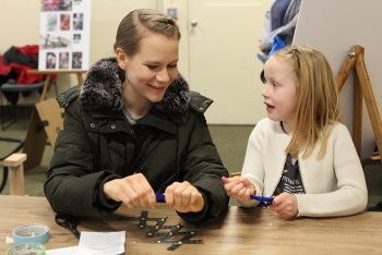 Fluor Idaho employee Jessica Anderson and her daughter Ellie working together to build a mechanical dinosaur arm.