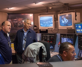 Under Secretary for Science Paul Dabbar (left) and Savannah River Nuclear Solutions Materials Disposition Engineer Mike Lewczyk watch as H Canyon Crane Operator Bruce Cain demonstrates using remote-control cranes.