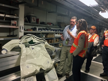 Jeremy Hampton of Fluor Idaho shows EM Assistant Secretary Anne Marie White a "bubble suit" worn by workers when they make entries into contaminated areas at the Advanced Mixed Waste Treatment Project.