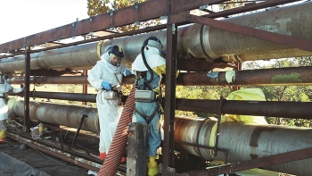 Workers foam tie lines to trap contaminants in place.
