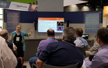 Photo of a woman giving a presentation to a crowd of people.