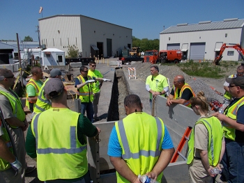 A multidisciplinary group of employees receive confined space training rescue at an onsite excavation work zone.