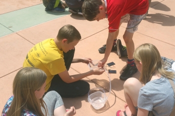 Middle school students learn about solar power out in the sunshine on Energy Day