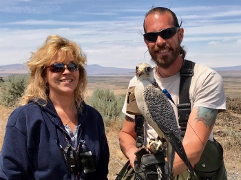 Hanford Site Radiological Control Technician Kathy Keelean, left, conducted a radiological survey on Jack the falcon. His handler, Chase H. Delles, is at right.