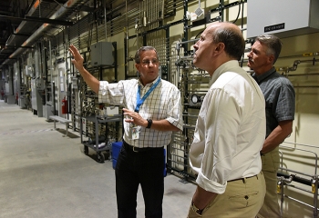 Fluor-Idaho Integrated Waste Treatment Unit (IWTU) Operations Manager Craig Olson, left, and DOE IWTU Project Manager Kevin OâNeill, behind, brief DOE Under Secretary for Science Paul Dabbar at IWTU.