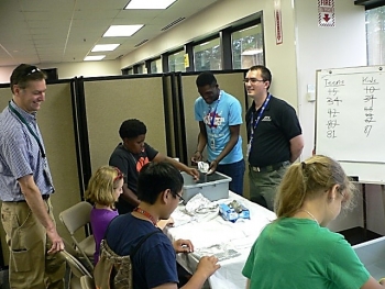 Kids design tinfoil boats with the challenge of keeping them afloat with the addition of coins.