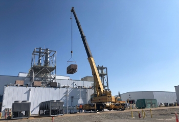 Workers remove an old chiller from atop the Advanced Mixed Waste Treatment Project's treatment facility.