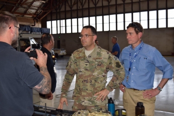 Col. Theodore Breuker, commander of security forces at Kirtland Air Force Base in Albuquerque, left, and Robert Suminsby, manager of the OST Office of Mission Operations, listen to an OST federal agent describe equipment used by agents.