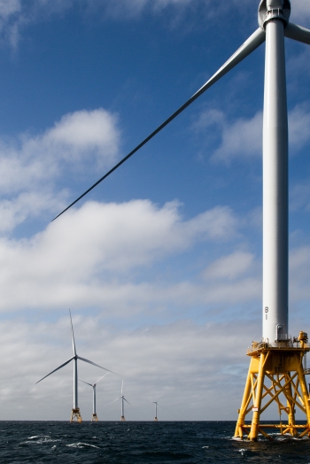 photo of several offshore wind turbines in the ocean.