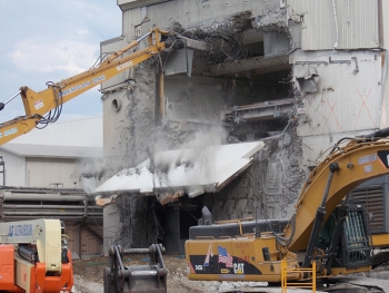 Crews use equipment to loosen and lower the 100-ton crane maintenance room shield door from the Vitrification Facility.