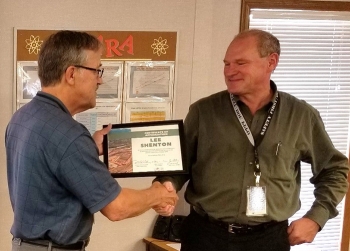 Lee Shenton, left, accepts a certificate of appreciation from Moab Federal Cleanup Director Russell McCallister.