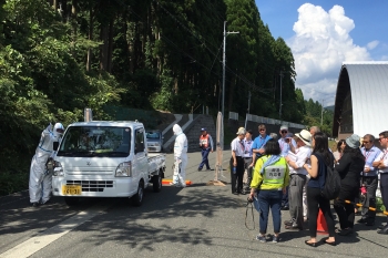 The observer group watching a vehicle pass through a radiation-screening station during the exercise.