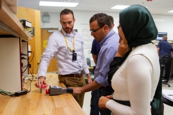 Los Alamos National Laboratory nuclear engineer Robert Weinmann-Smith shows participants how to use a handheld IAEA inspector tool, called identiFINDER, to detect radioactive materials.