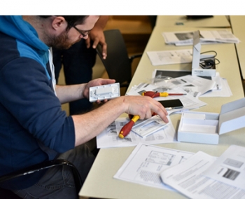Photo of a man looking at a phone and instruction manuals.