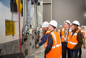 Equipment operator, Dwight Bowman, demonstrates a manipulator moving objects in the mock-up of a 324 Building hot cell for DOE Chief Financial Officer John Vonglis, Richland Operations Office Manager Doug Shoop, and EM Assistant Secretary Anne White.