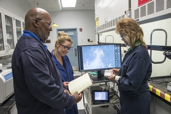 Rodney Gantt, laboratory specialist, Linda Youmans, director of the Industrial Hygiene Laboratory, and Becky Chavous, laboratory specialist, test the new radiological asbestos monitoring equipment to ensure it meets laboratory accreditation requirements.