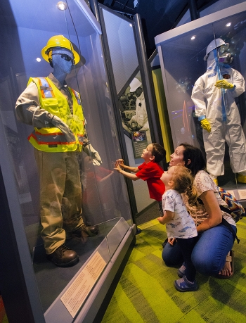 Exhibit of equipment and suits that keep employees safe as they perform cleanup.