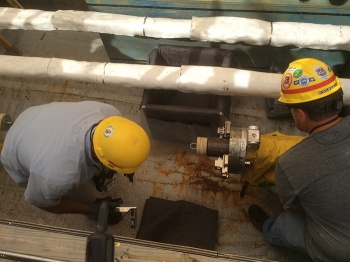 Workers practice waste transfer line modification work in a mock-up area.