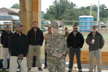 Front row: Vincent Fisher, Office of Secure Transportation Assistant Deputy Administrator, left, and Mark Berry, Arkansas Army National Guard Adjutant General Major lead an opening ceremony for the new facility at Fort Chaffee, Arkansas.