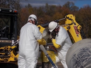 Crews pour grout into the well pump casing to stabilize it before pulling out the well pump.