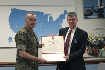 Keith Hamilton is presented with Department of Navy Superior Civilian Service Award by Major Gen. Vincent A. Coglianese, Marine Corps Installation Commander.