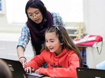 Los Alamos Lab researcher works with an elementary school student during an Hour of Code session.