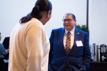 Two men standing and talking to each other.