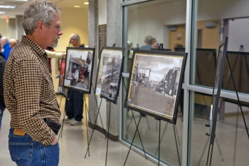 Attendee reads the interpretive information on one of the displayâs historic photos.