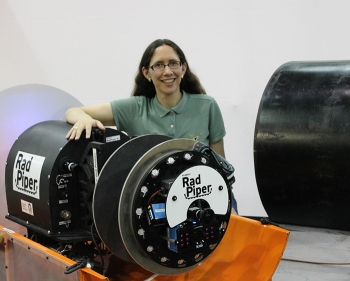 Heather Jones, a senior project scientist at Carnegie Mellon University, stands with one of the Radpiper robots.