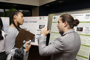 DOE Fellow Anibal Morales explains his research to EM Office of Technology Development Engineer Genia McKinley at the recent DOE Fellows Poster Exhibition and Competition.