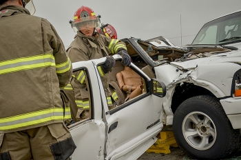 EM site firefighters access occupants trapped in a vehicle in a mock accident.