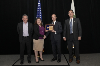 From left: Brett Cederdahl, TWF Contractor Project Manager; Janelle Armijo, prior TWF Federal Project Director (FPD) accepting on behalf of Thomas Whitacre, current TWF FPD; Mark Menezes, Under Secretary for Management & Performance; and Everett Trollinge