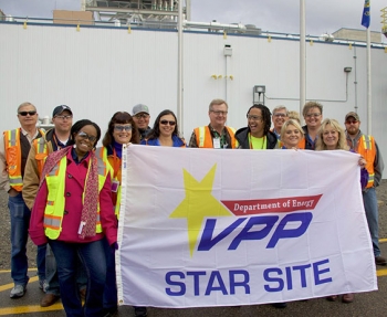 Fluor Idaho employees hold up their DOE Voluntary Protection Program flag.