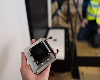 Hand holding the electrochemical humidity control device prior to installation at the Statue of Liberty Museum.